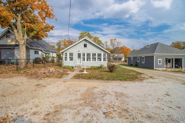 rear view of house featuring a sunroom and fence