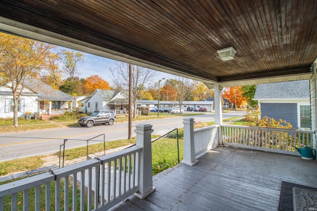 wooden terrace with covered porch and a residential view