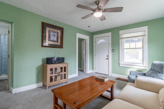 living area with visible vents, ceiling fan, carpet, and baseboards