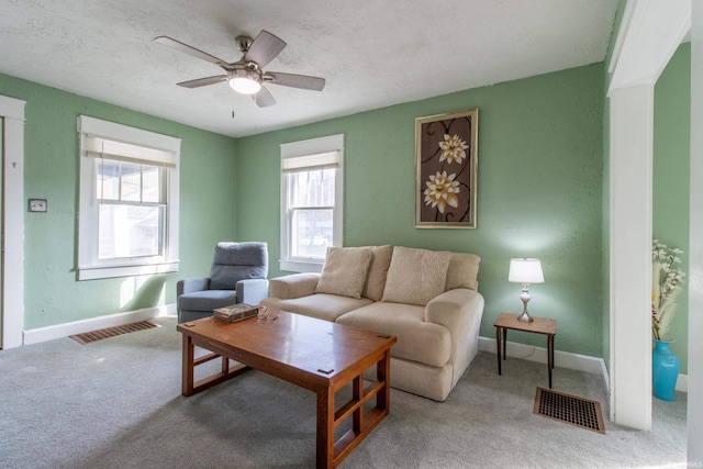 carpeted living area featuring visible vents, baseboards, and a ceiling fan