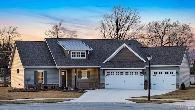 view of front of home with stone siding, an attached garage, driveway, and a front yard