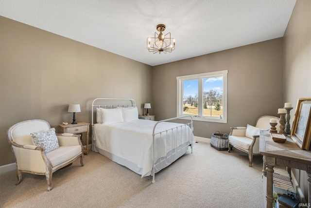 bedroom featuring a chandelier, light colored carpet, and baseboards