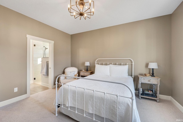 carpeted bedroom featuring a chandelier, ensuite bath, and baseboards