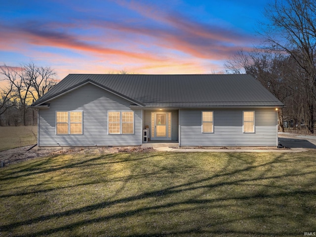 ranch-style home with a front yard and metal roof