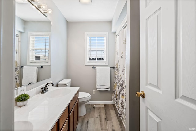 full bathroom featuring a wealth of natural light, toilet, vanity, and wood finished floors