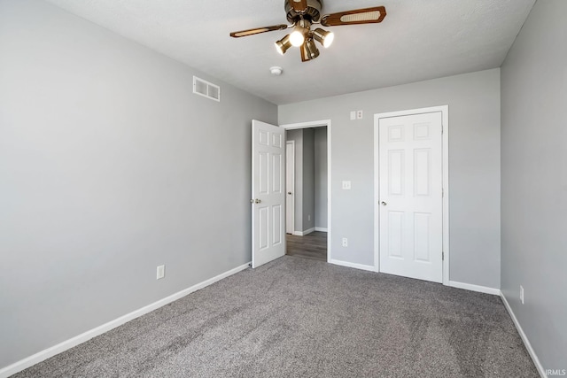 unfurnished bedroom with visible vents, baseboards, carpet, and a ceiling fan