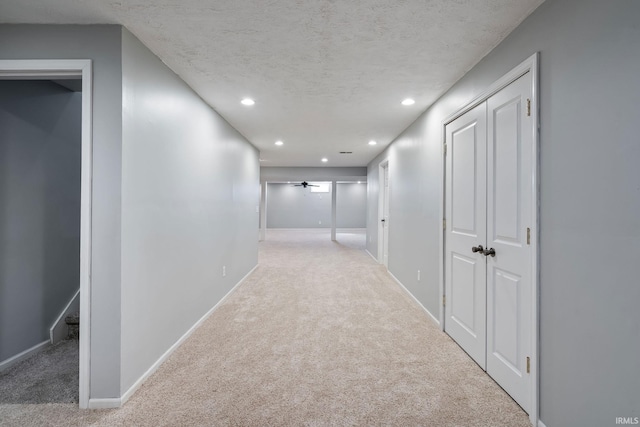 hall featuring recessed lighting, baseboards, carpet floors, and a textured ceiling