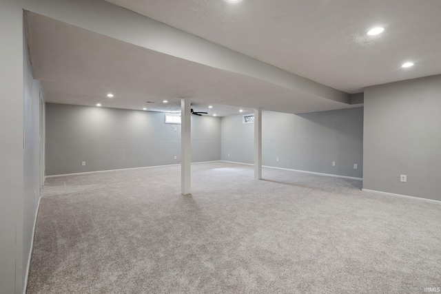 below grade area featuring recessed lighting, baseboards, and light carpet