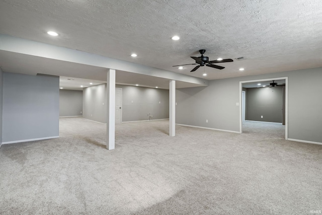 finished below grade area featuring visible vents, baseboards, light colored carpet, recessed lighting, and a textured ceiling