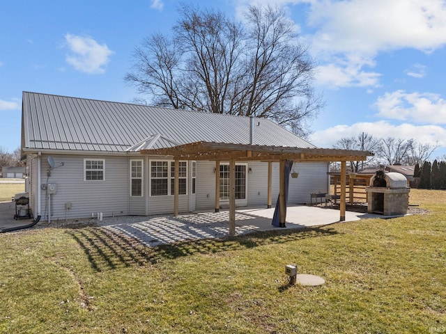 back of house featuring a patio, a lawn, and metal roof