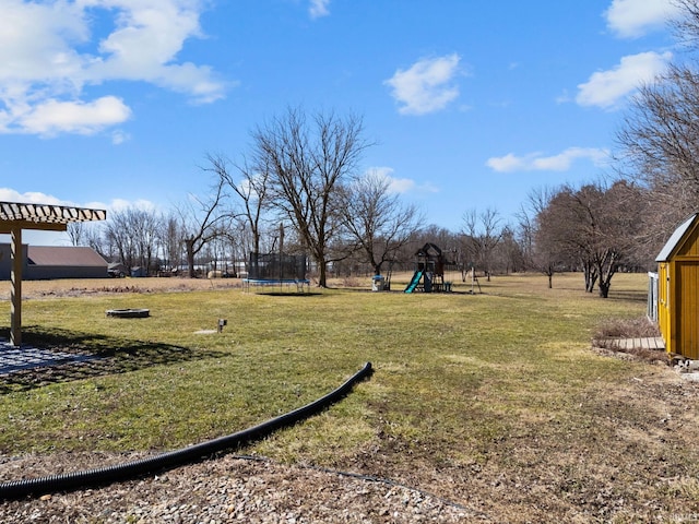 view of yard featuring playground community and a trampoline