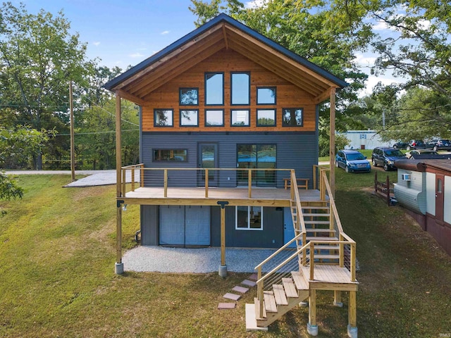 rear view of property featuring stairway, a lawn, and a deck