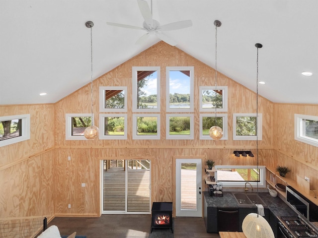 interior space with high vaulted ceiling, a sink, wood finished floors, recessed lighting, and wooden walls