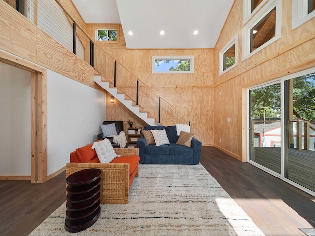 living area featuring wooden walls, a high ceiling, and wood finished floors