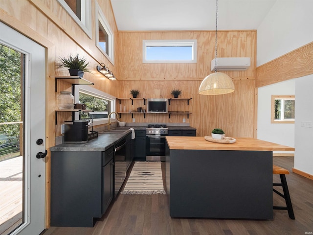 kitchen with stainless steel range with gas cooktop, wooden counters, dark wood finished floors, open shelves, and a wall mounted air conditioner