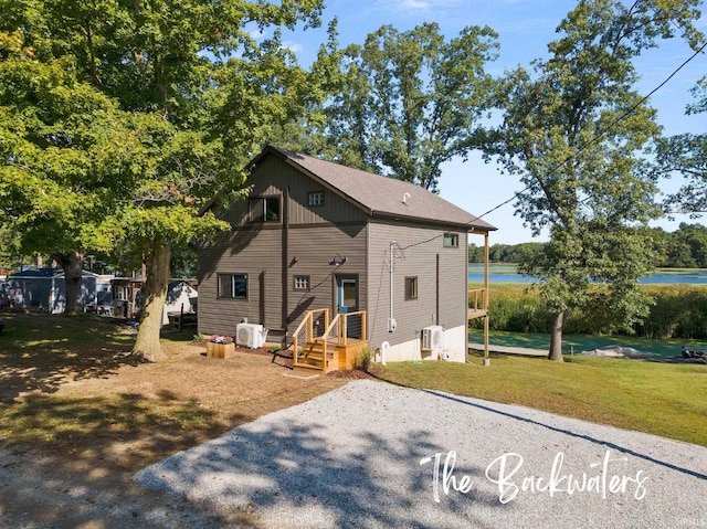 rear view of house featuring a yard and a water view