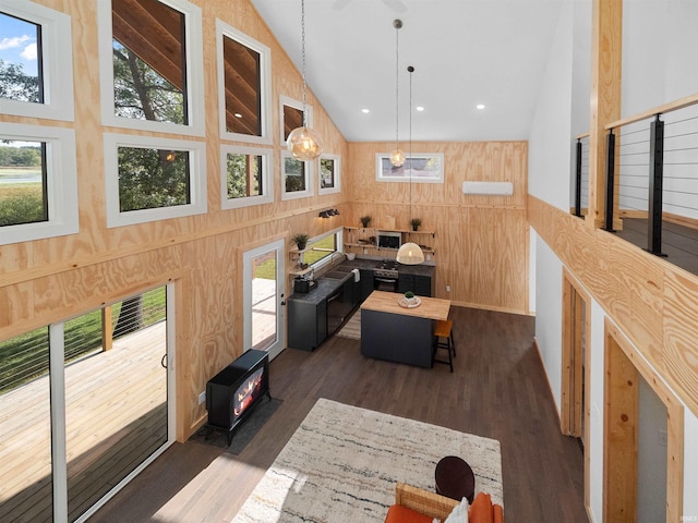 living room with high vaulted ceiling, a healthy amount of sunlight, and dark wood finished floors