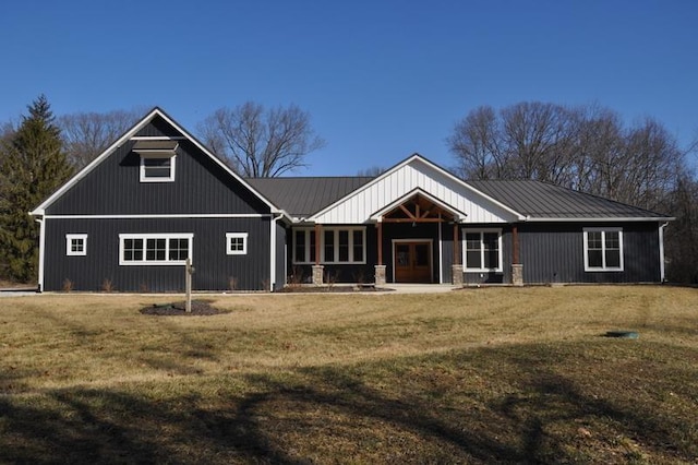 view of front of house featuring metal roof and a front yard