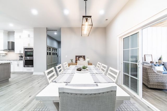 dining area with visible vents and light wood-style flooring