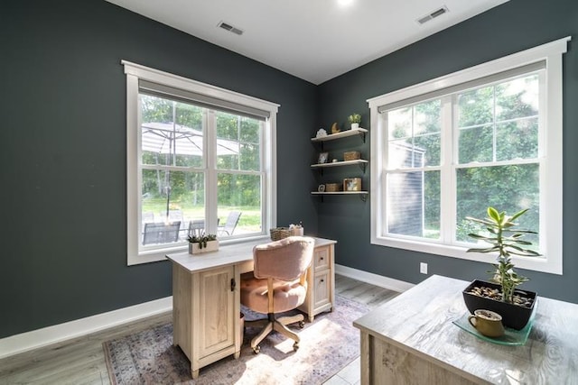 home office featuring visible vents, light wood-type flooring, and baseboards