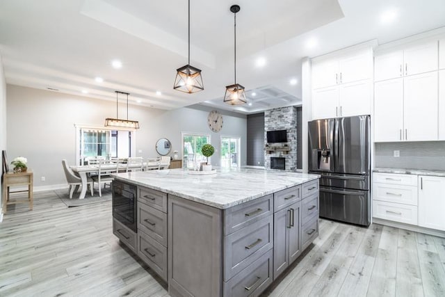 kitchen featuring built in microwave, stainless steel fridge, gray cabinets, and white cabinets