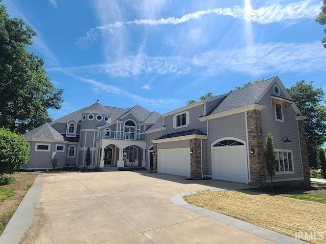 view of front of home featuring concrete driveway, a balcony, and a garage