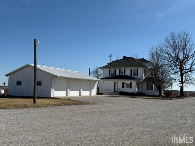 view of front of house with a garage and an outbuilding