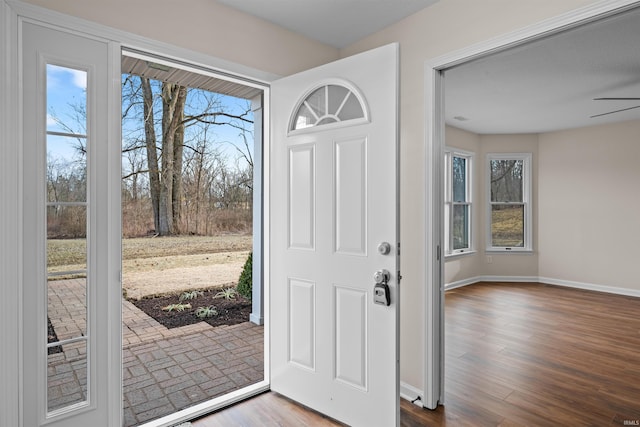 foyer featuring a ceiling fan, baseboards, and wood finished floors