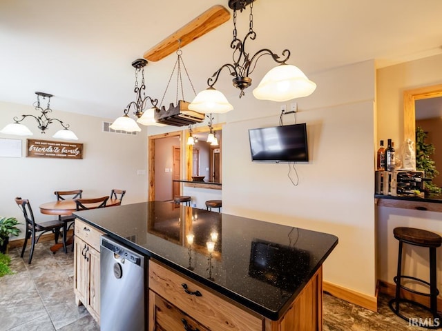 kitchen featuring visible vents, a center island, baseboards, pendant lighting, and dark stone countertops