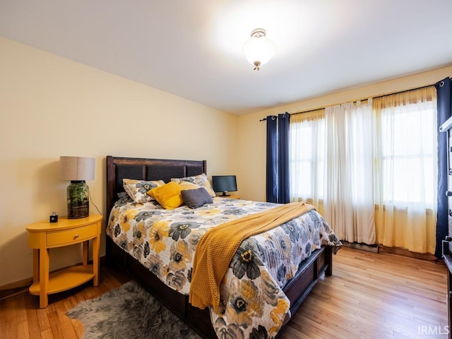 bedroom with wood finished floors and baseboards