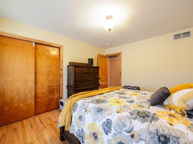 bedroom featuring visible vents, a closet, and light wood finished floors