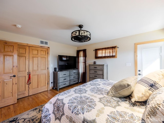 bedroom featuring visible vents and wood finished floors