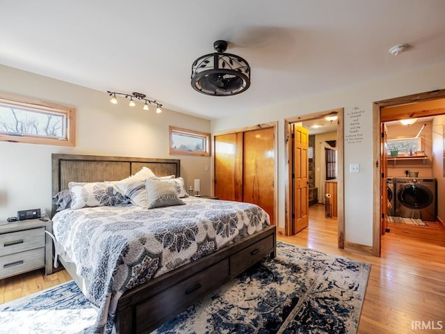 bedroom with a closet, independent washer and dryer, and light wood-type flooring