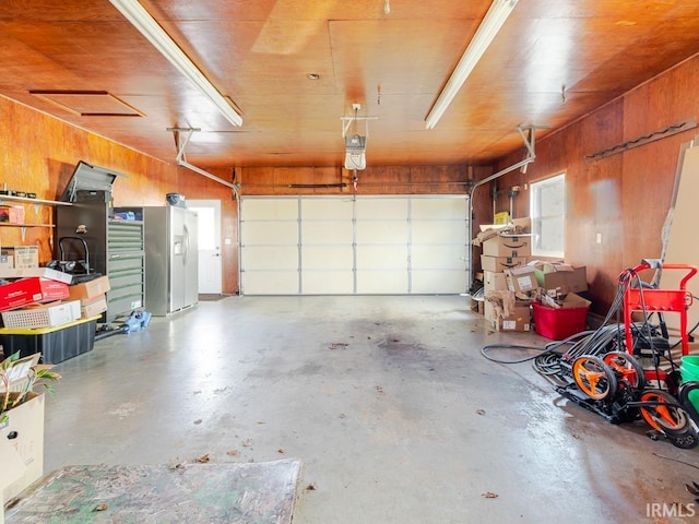 garage with wood walls and a garage door opener