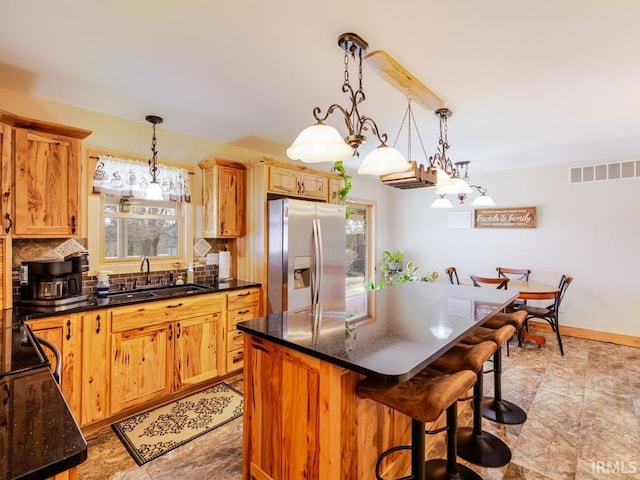 kitchen featuring a wealth of natural light, visible vents, a sink, and stainless steel fridge with ice dispenser