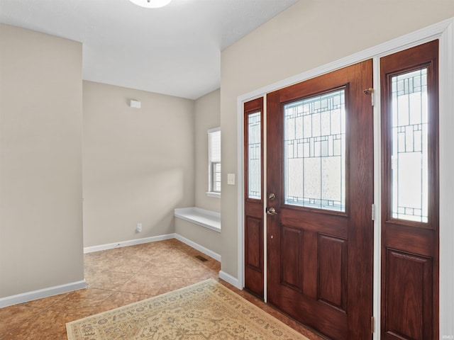 foyer with light tile patterned floors, visible vents, and baseboards