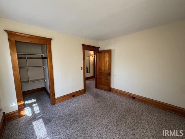 unfurnished bedroom with a closet, baseboards, carpet floors, and a spacious closet