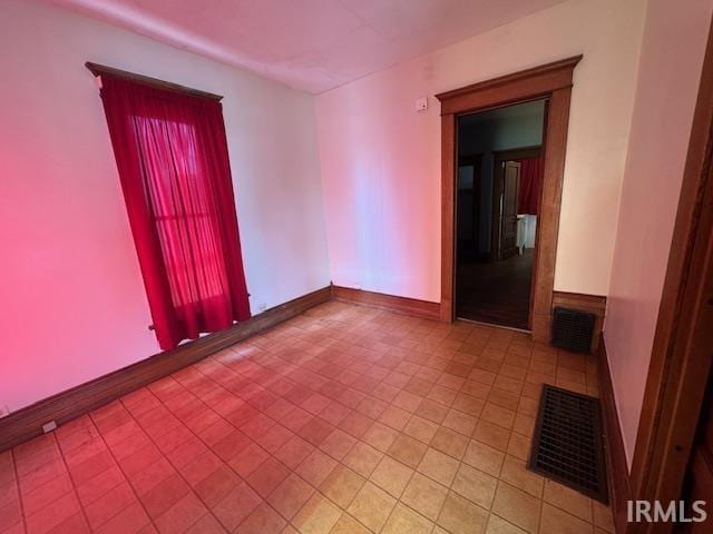 unfurnished room with visible vents and baseboards
