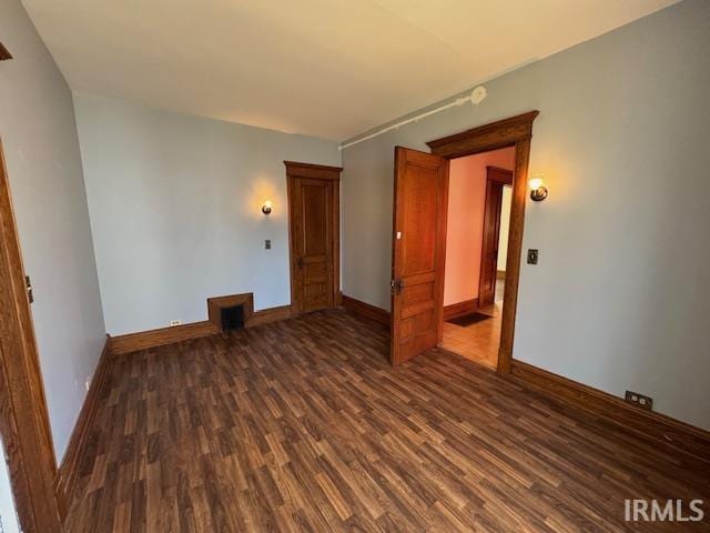 spare room with dark wood-style floors and baseboards