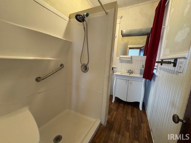 full bathroom with a shower stall, vanity, and wood finished floors