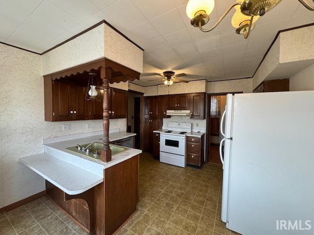 kitchen with dark brown cabinets, under cabinet range hood, light countertops, a peninsula, and white appliances