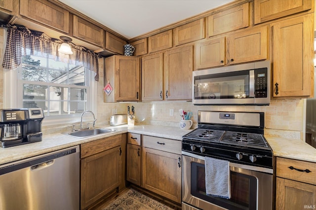 kitchen with a sink, tasteful backsplash, appliances with stainless steel finishes, and light countertops