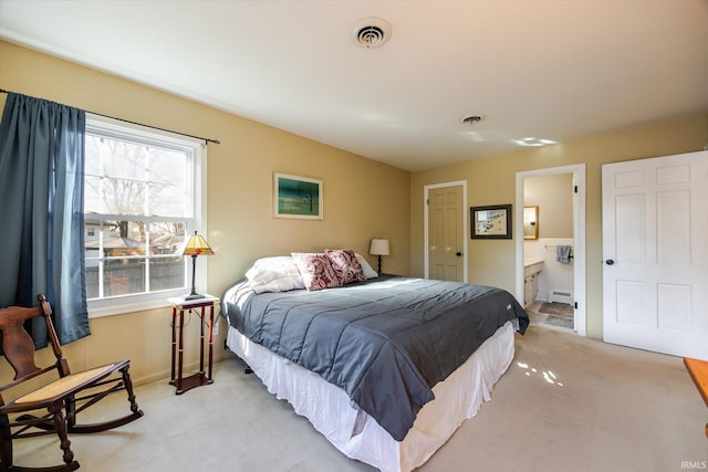 bedroom featuring light carpet, visible vents, connected bathroom, and a baseboard heating unit