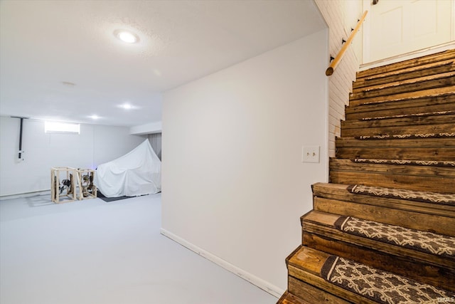 stairs with recessed lighting, baseboards, and finished concrete floors