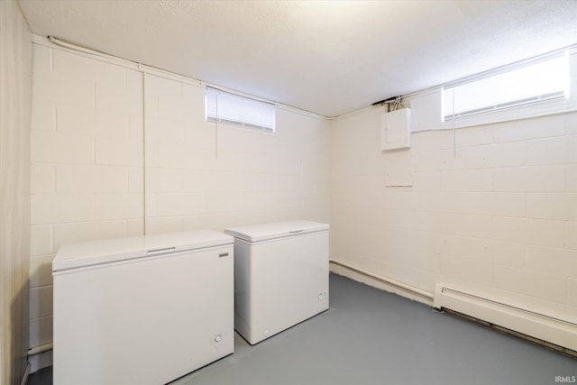 washroom with laundry area, independent washer and dryer, baseboard heating, and a textured ceiling