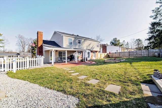 back of property featuring a patio area, a fenced backyard, a lawn, and a chimney