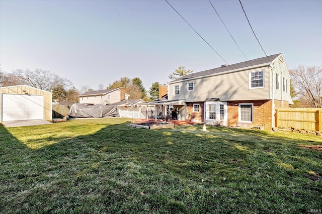 back of house featuring a yard, an outbuilding, brick siding, and a fenced backyard