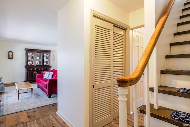 stairs featuring wood finished floors and baseboards