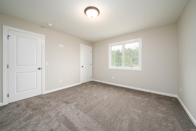 unfurnished bedroom with baseboards, visible vents, and carpet floors