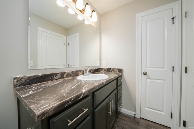 bathroom featuring vanity, wood finished floors, and baseboards